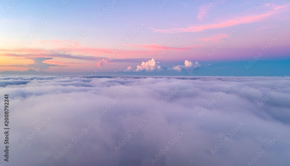 Fototapeta premium Aerial view of a sea of clouds bathed in the soft hues of a pastel sunrise sky