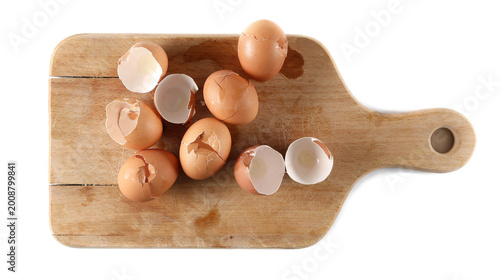 Quadro su tela Cracked eggshell pile, crushed egg shells on chopping board isolated on white ba