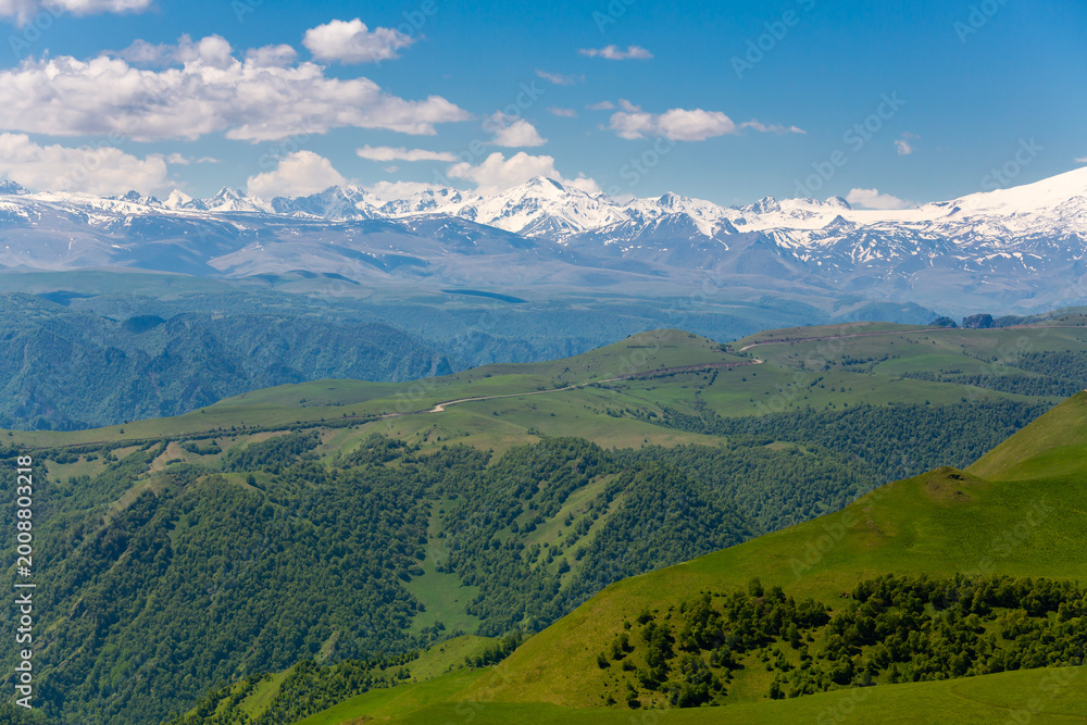 Fototapeta premium Landscape of Main Caucasus range and green mountain slopes at summer travel