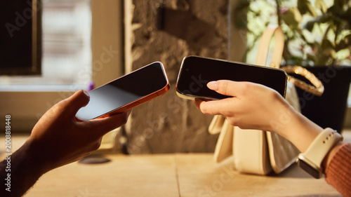 Fotografie Close up of two smartphones held together for digital payment exchange