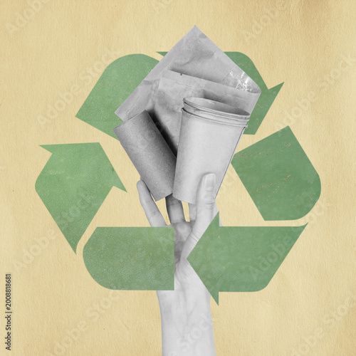 Hand holding various paper waste items in front of a green recycling symbol