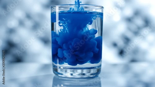 Blue liquid swirling in glass jar close-up macro