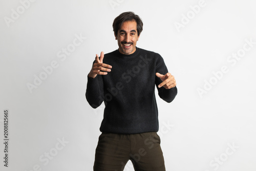 Tableau sur toile Happy man poses playfully in a cozy black sweater for a stylish shoot