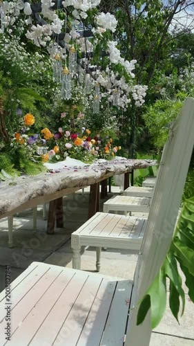 Cinematic shot of floral decoration against blue sky in garden setting. Bright natural lighting enhances color and atmosphere, perfect for wedding, celebration, and outdoor lifestyle visuals.