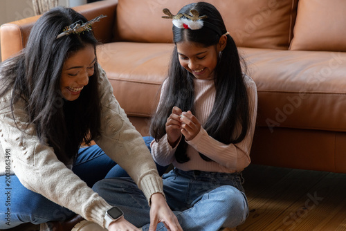 Εκτύπωση καμβά Diverse mother and daughter sitting at home wearing antler headbands, daughter h