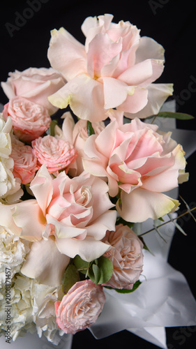 фотографія An exquisite floral arrangement in a delicate flesh-colored hatbox with roses and eustoma