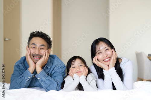 Fotografie ホテルのベッドで頬杖をつく日本人親子