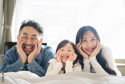 Fotografie ホテルのベッドで頬杖をつく日本人親子