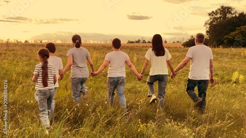 Sunset family adventure, Kids and parents stroll, Hand in hand at dusk, Loving relationships, Strength in unity, Family happiness outdoors, Rural harmony, Walking to the horizon, Evening serenity
