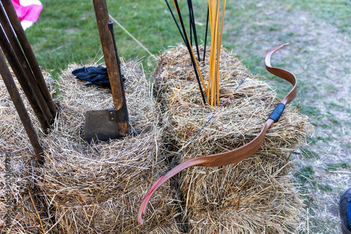 Foto Traditional wooden bow with arrows on hay bales at outdoor archery setup