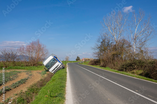 фотографія A tarpaulin truck went off the road after a bend