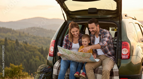 Happy family of three sitting in an SUV trunk, reading a map and discussing their route during a scenic road trip. Summer travel and vacation concept, copy space.