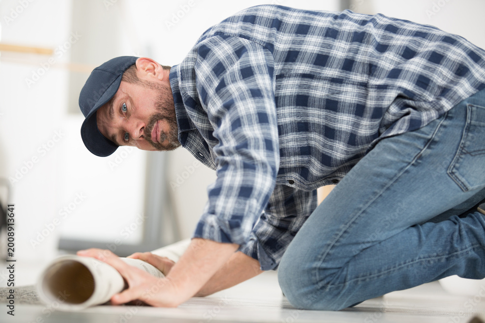 Fototapeta premium man posing the carpet roll on floor