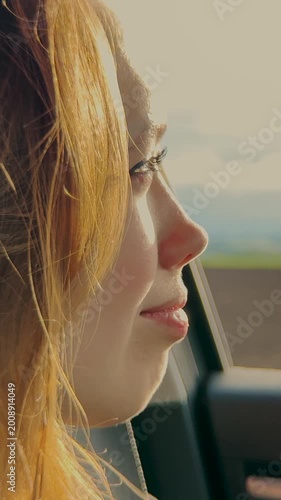 Blonde girl, car journey, smiling through window, sunlight reflections, enjoying ride, adventure mood, positive emotions, natural beauty, travel excitement, bright day, Woman looking out of car, smile