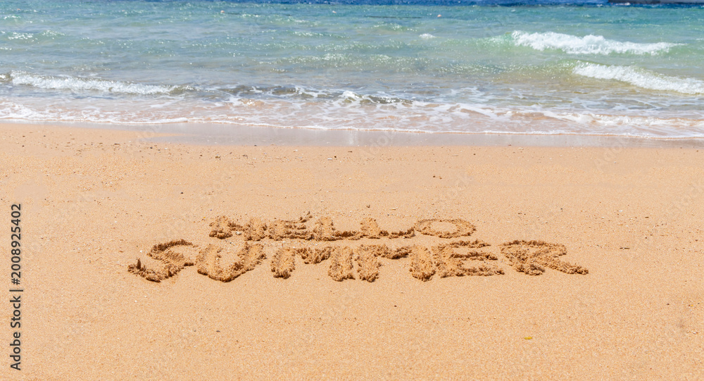 Fototapeta premium Hello summer words concept. Concept word Hello summer written on beautiful Red sea sand beach. Beautiful Red sea ocean sand beach background, copy space. Business travel Hello summer concept.