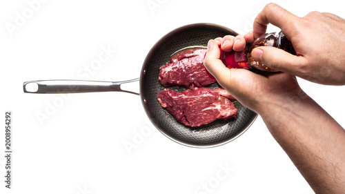 Photos Marbled beef steak on frying pan isolated on white background