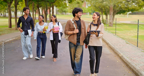 Indian young adult gen z busy boy girl use tab look screen talk share new online e learning study plan place. pupil female male man group speak funny gossip enjoy break day have fun joy park