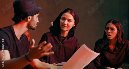Indian young adult gen z male man female group hold script paper read new story line learn drama at studio teen girl boy team talk speak share new plan idea enjoy day spend break time hall stage place