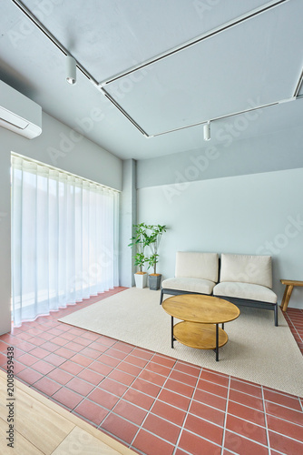 Bright minimalist living room with sofa, plants and natural light by window