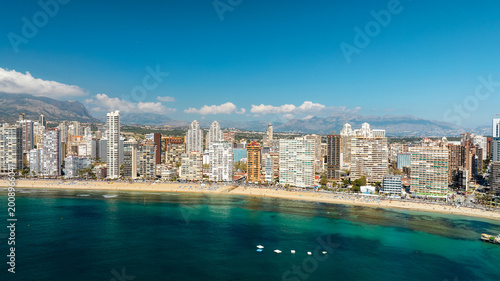 Bild auf Leinwand Benidorm Spain aerial drone view seaside resort modern architecture skyscrapers blue sky mountains background summer tourism holiday destination scenic