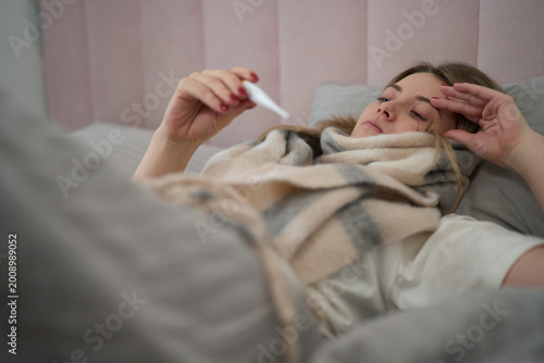 Sick Day Rest with Thermometer in Hand