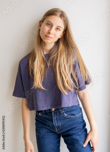 Konstfotografi Portrait of a 12-year-old blonde pre-teen girl wearing a blue sports t-shirt and