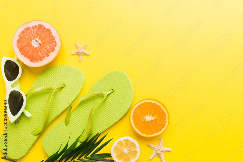 Fototapeta premium Top view composition of flip flops placed with beach accessories top view on table background. Tropical summer vacation concept Flat lay