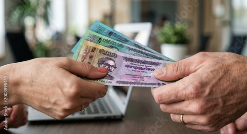 Obraz na płótnie Close Up of Hands Exchanging Bangladeshi Taka Banknotes Indoors – Bangladesh Cur