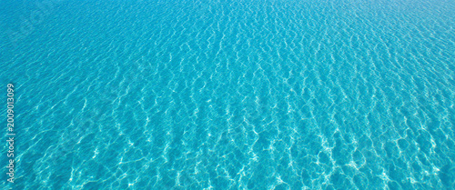 An aerial view of a large region of clean, clear, blue water ripples