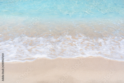 Tableau sur toile Bright blue ocean waves rolling, soft white sandy beach with foamy surf, clear w