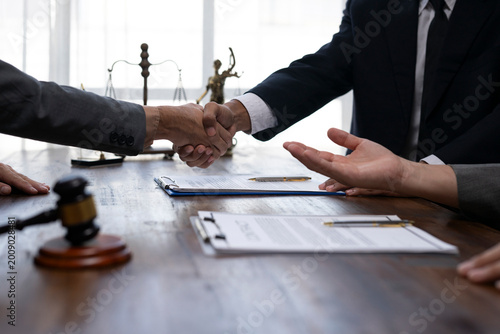 Canvas-taulu Lawyers shaking hands after signing a business contract in a law firm
