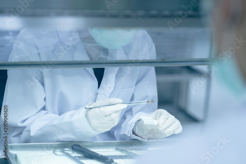 Konstfotografi Forensic pathologist extracting trace evidence specimen via precision forceps
