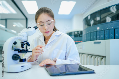 Photos Digital pathologist integrating optical microscopy analysis with telepathology tablet interface
