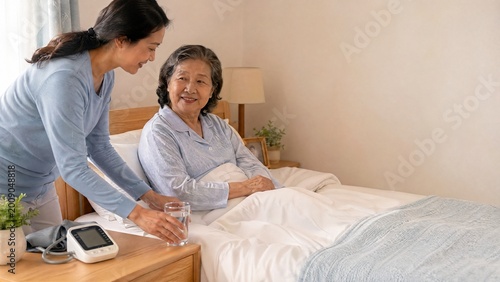 Caregiver assisting elderly woman with glass of water in bedroom  