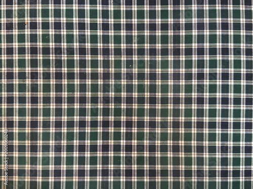 Close up of green fabric flannel with tartan pattern. In green, black, and white checkerboard pattern. Flannel or tartan style is very common in scarf, shirts, and fashion industry. Seamless backgroun