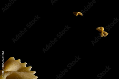 Abstract space concept of Farfalle pasta orbiting in a dark void like satellites.