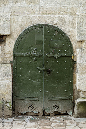 Ancient green metal arched entrance door