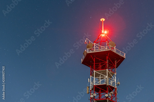 Night View of Telecommunications Tower with Red Technical Lighting and Starry Sky