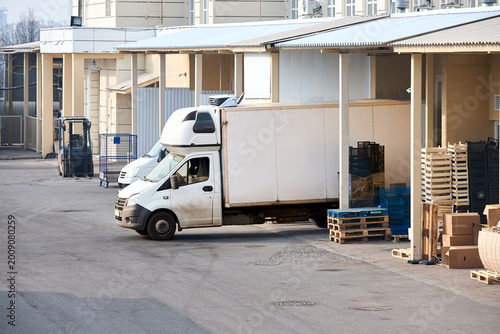 Schilderij op canvas Distribution center with loading bays shipping containers forklift and transport vehicles