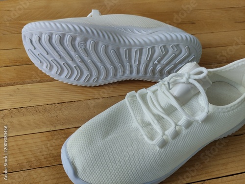 White fabric sneakers on the wooden background