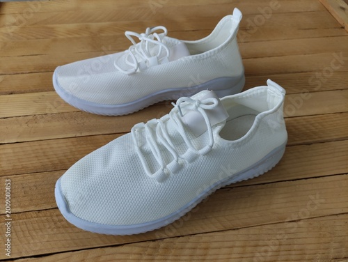 White fabric sneakers on the wooden background