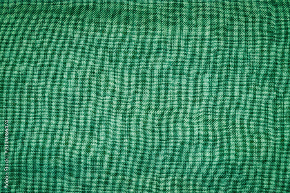 Fototapeta premium Green fabric texture showing a plain surface used for various purposes in design and crafts