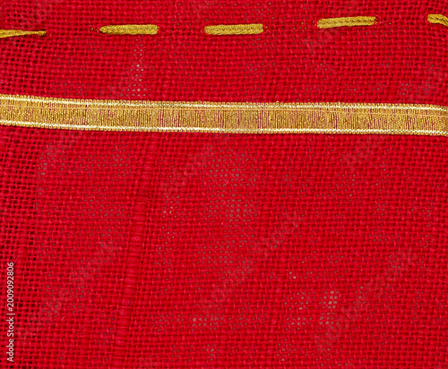Schilderij op canvas Handmade red fabric with golden thread details on display in a textile market in