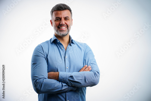 Confident male entrepreneur arms crossed isolated white background