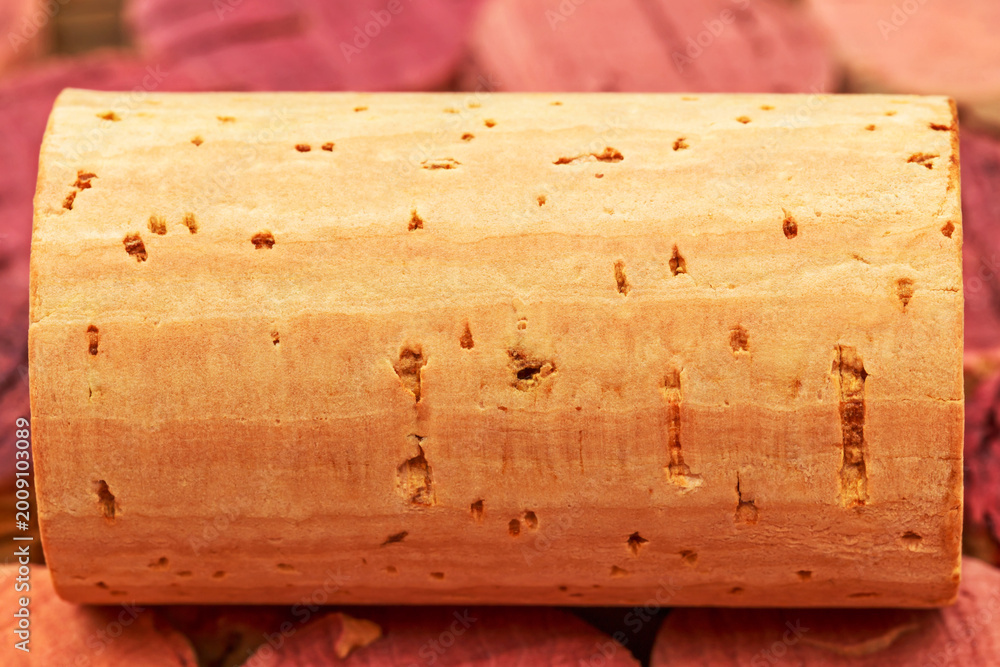 Fototapeta premium Cork resting on a pile of colored cork slices in a natural setting during daylight hours