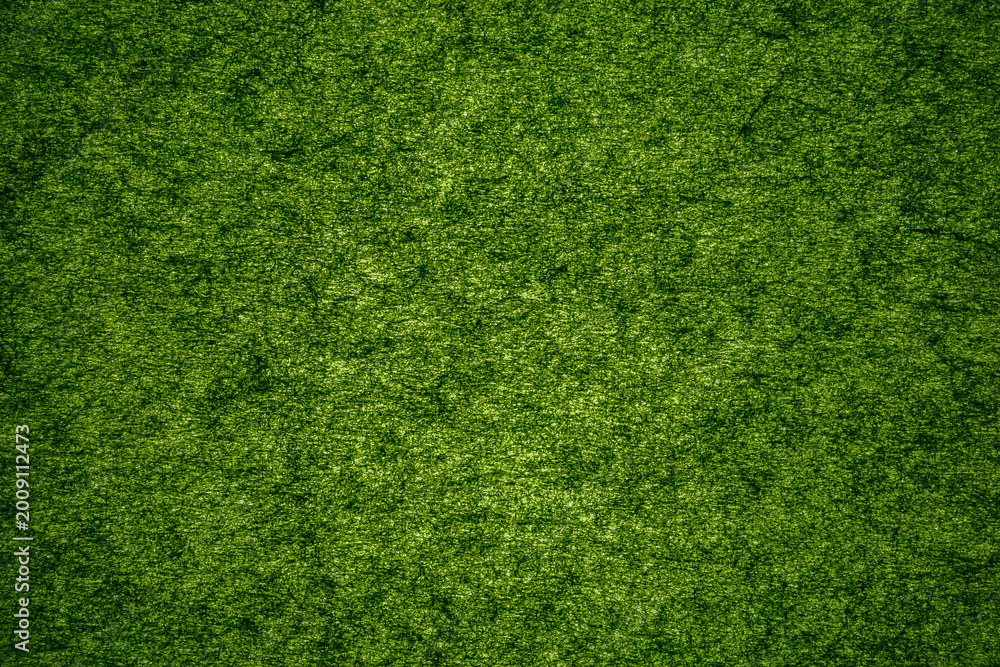 Fototapeta premium Bright green textured surface shows fibers and threads in a close-up view
