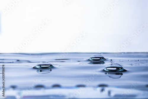 207.Dome-Shaped Droplets on Blue-White Water Surface