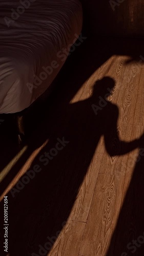 Vertical video. Long Shadow of Woman Walking across Wooden Floor in Bedroom toward Window Opening Curtains Morning Sunlight Casting Dramatic Silhouette Calm Wake Up Lifestyle Scene