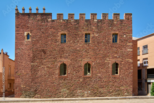 Foto Architectural detail of the Torre del Baro monument, featuring historic battlements and Gothic-style windows on a sunlit afternoon in the Mediterranean