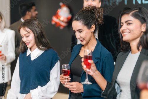 Women social party celebration holding glass of red drink in indoor event with smile and conversation